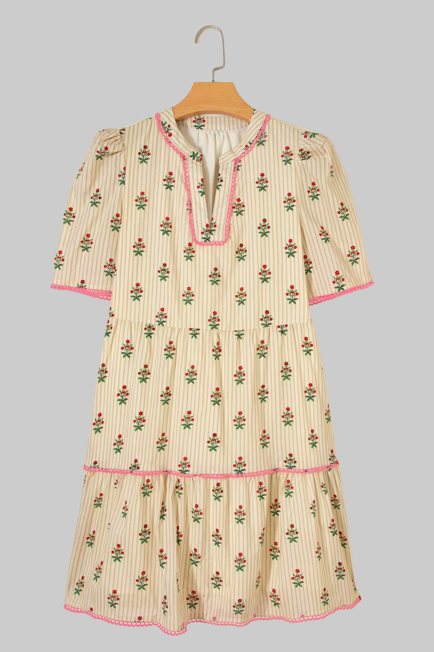 Floral-patterned dress on a hanger against a light gray background